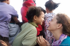 a boy and a woman share a moment of joy together behind a group of children