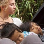 two children sleeping on a woman's lap