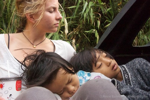 two children sleeping on a woman's lap