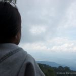 an over the shoulder shot of a girl looking towards a mountain
