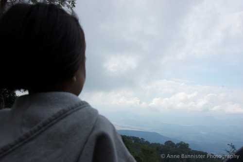 an over the shoulder shot of a girl looking towards a mountain
