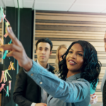 Woman pointing to notes and charts for colleagues