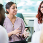 Smiling woman gestures in a meeting