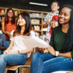 Students listen and smile in a library during a lecture