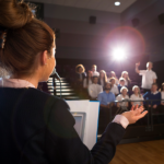 A young woman answers questions to a small group of people