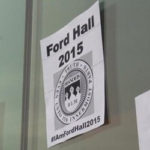 A black and white paper sign that says Ford Hall 2015 hangs on a wall