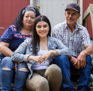 Student is sitting with her parents in a loving way