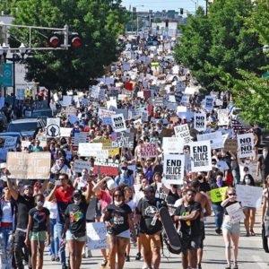 thousands of protestors flood the streets with signs like 'no justice no peace'