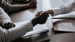 Two people shaking hands, close up on the hands.